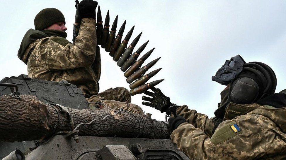 جنود أوكرانيون يتبادلون الذخيرة.