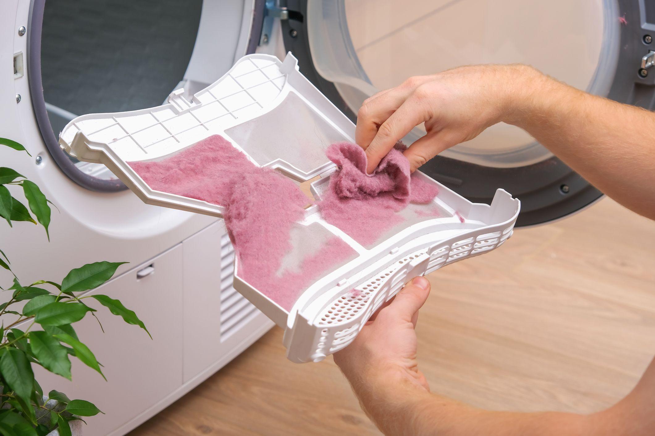 Mulher limpando filtro de máquina secadora de roupas