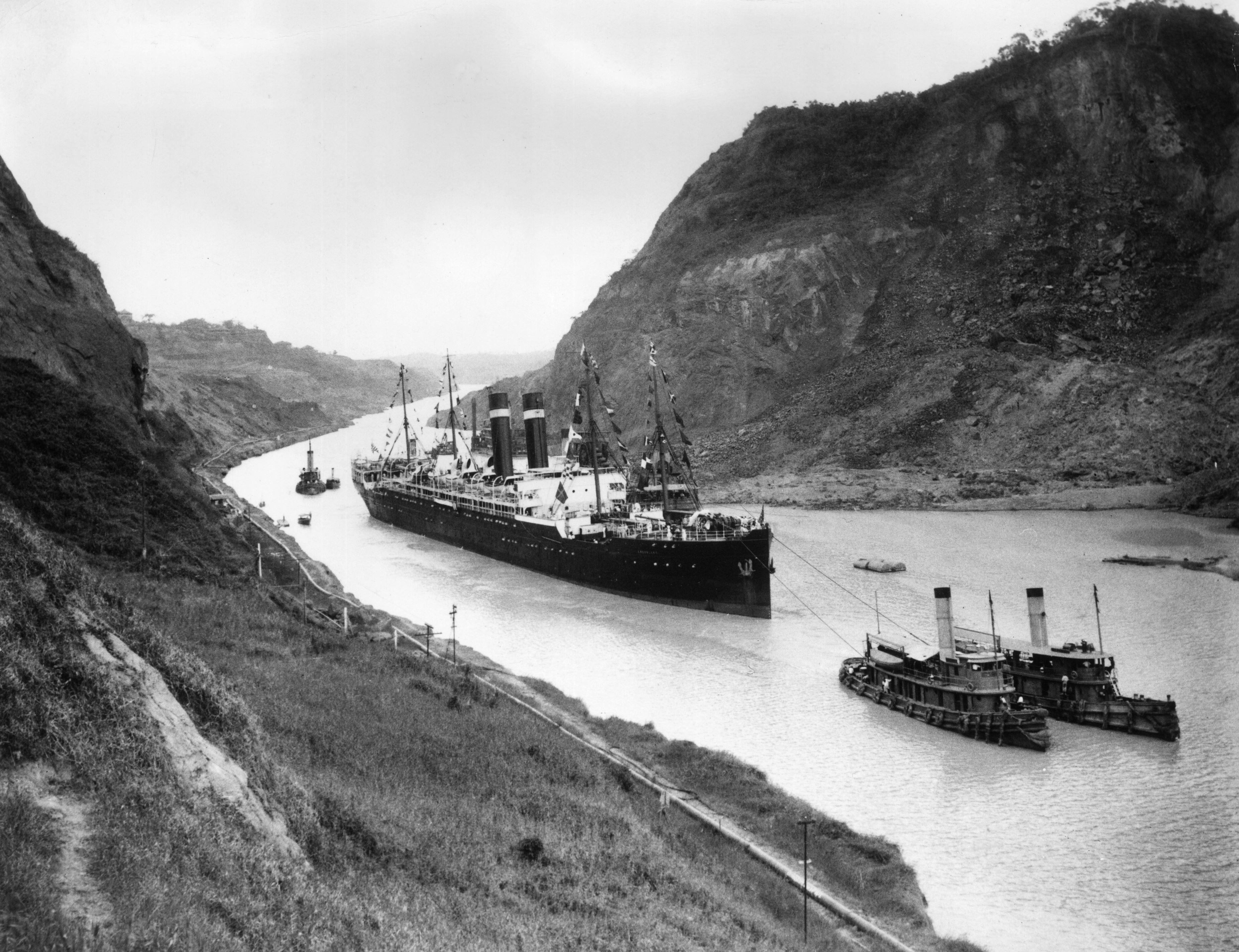 Un barco de EE.UU. pasa por el Canal de Panamá llevado por dos remolcadores en 1915.