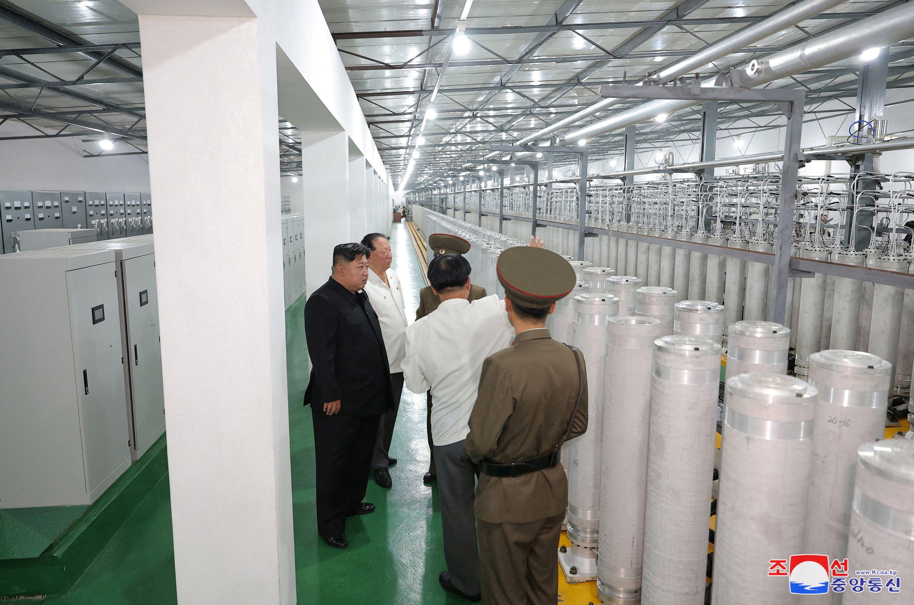 Kim recorriendo la instalación nuclear junto a funcionarios civiles y militares.