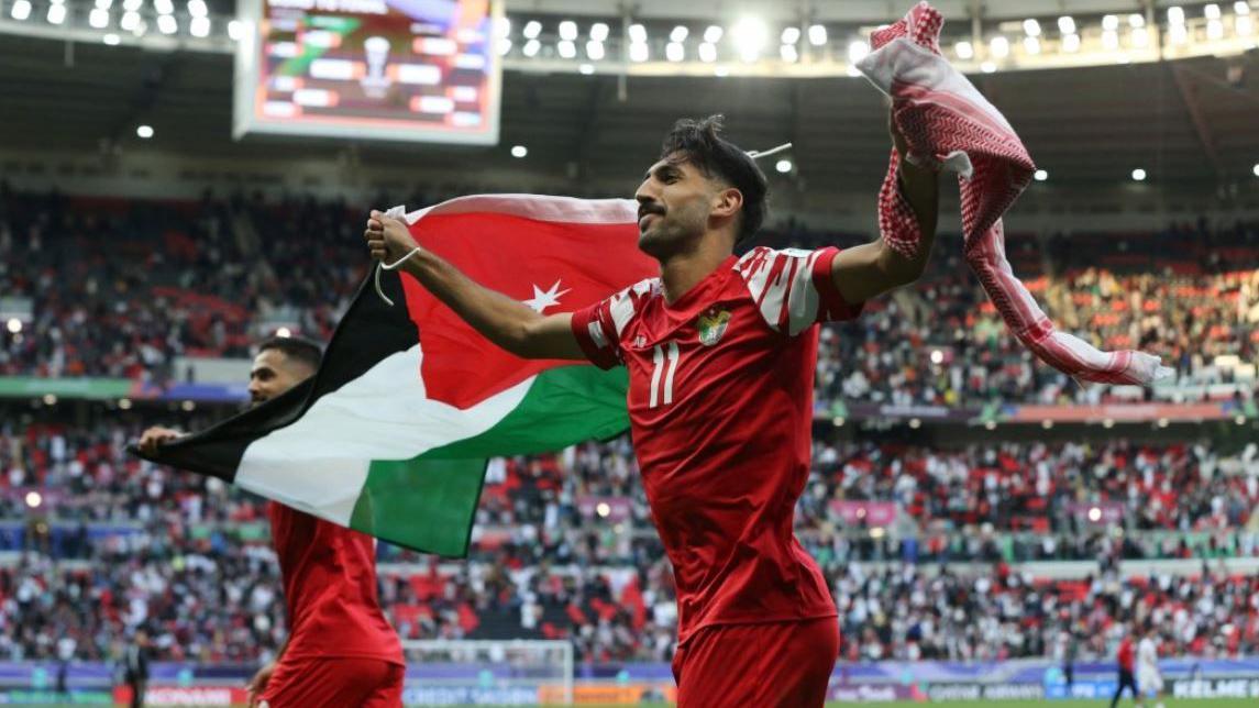 اللاعب الأردني يزن النعيمات يحمل العلم الأردني ويحتفل بفوز منتخب بلاده على منتخب طاجيكستان