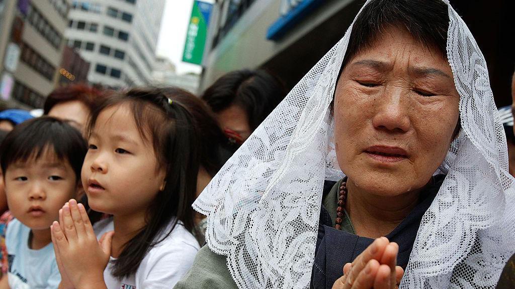 Fiéis católicos orando antes de uma missa do Papa Francisco na Catedral de Myeong-dong, em 18 de agosto de 2014, em Seul, Coreia do Sul