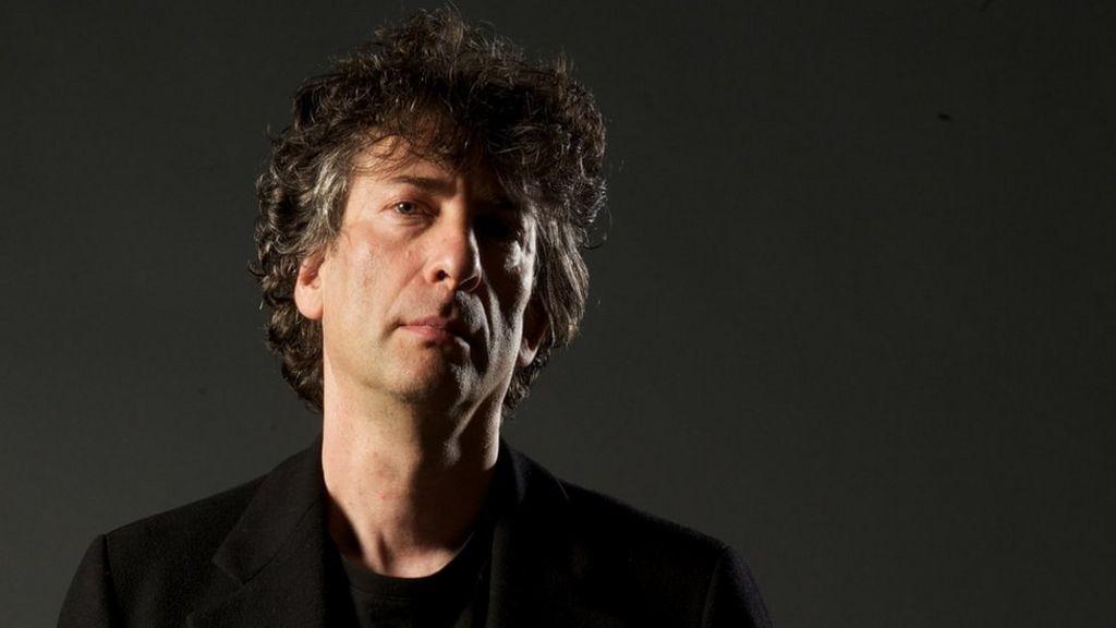 Neil Gaiman mais jovem, um homem branco de cabelo nas orelhas e roupas pretas