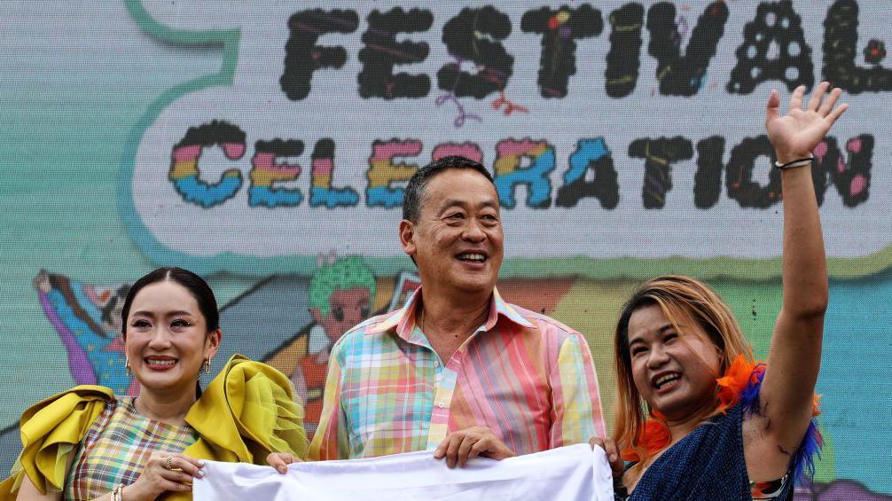 Paetongtarn Shinawatra (à esquerda) e seu antecessor Srettha Thavisin (centro) sorrindo ao lado de um ativista na Parada do Orgulho LGBT de Bangkok