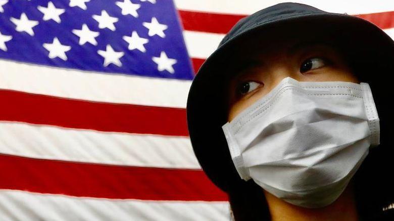 Mujer taiwanesa con la bandera de Estados Unidos a su espaldas.