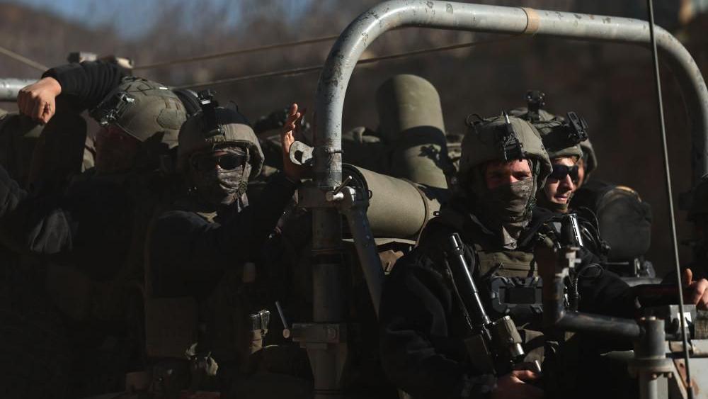 heavily armed troops in a jeep