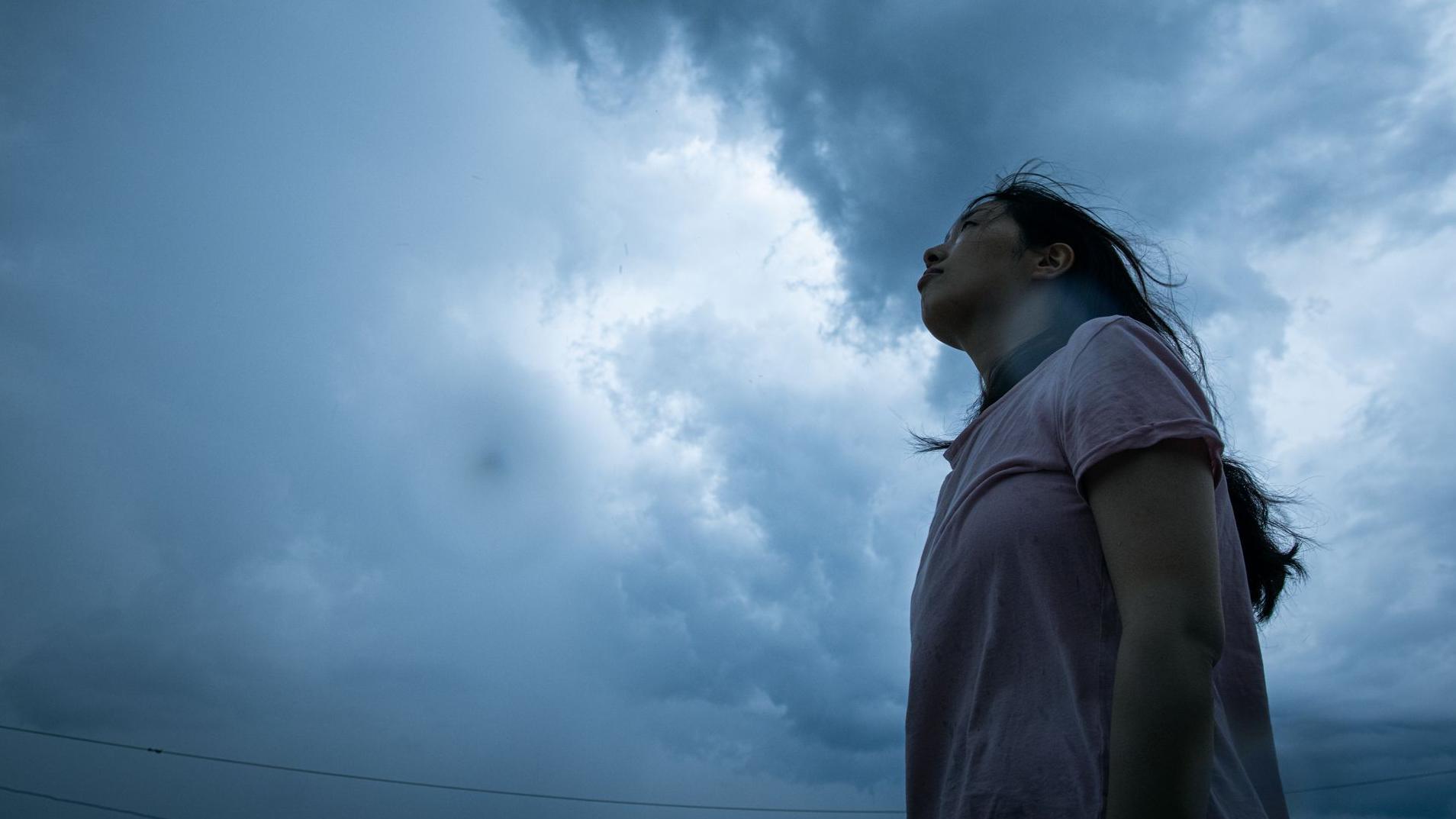 Fırtına bulutlarına bakan bir kadın