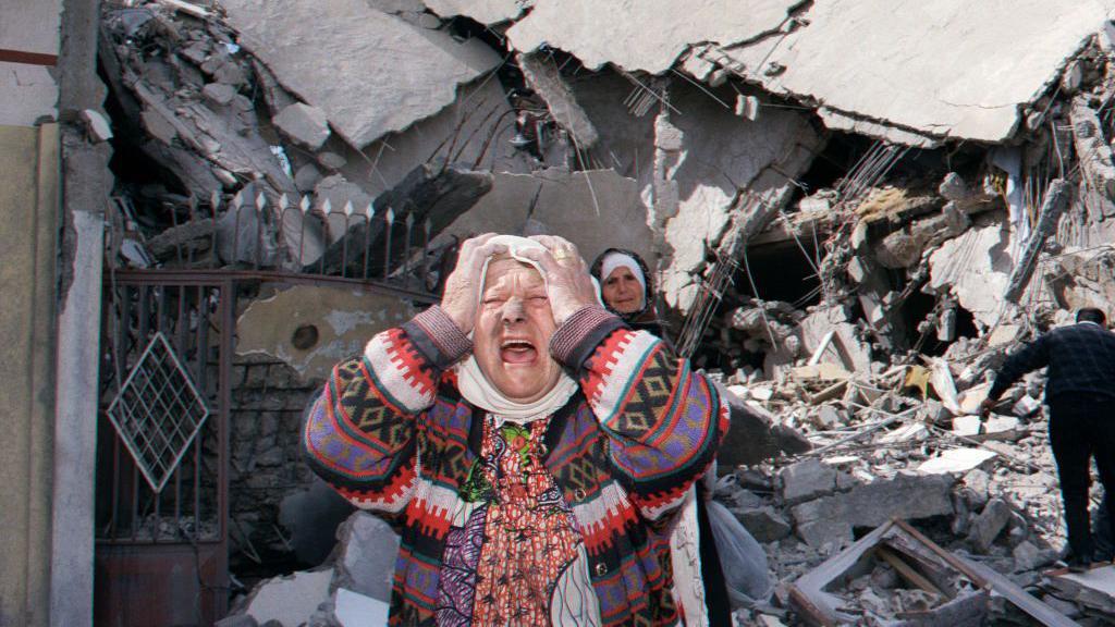 Seorang perempuan Lebanon kembali ke rumahnya yang hancur di kota Tebnin di Lebanon selatan pada 27 April 1996