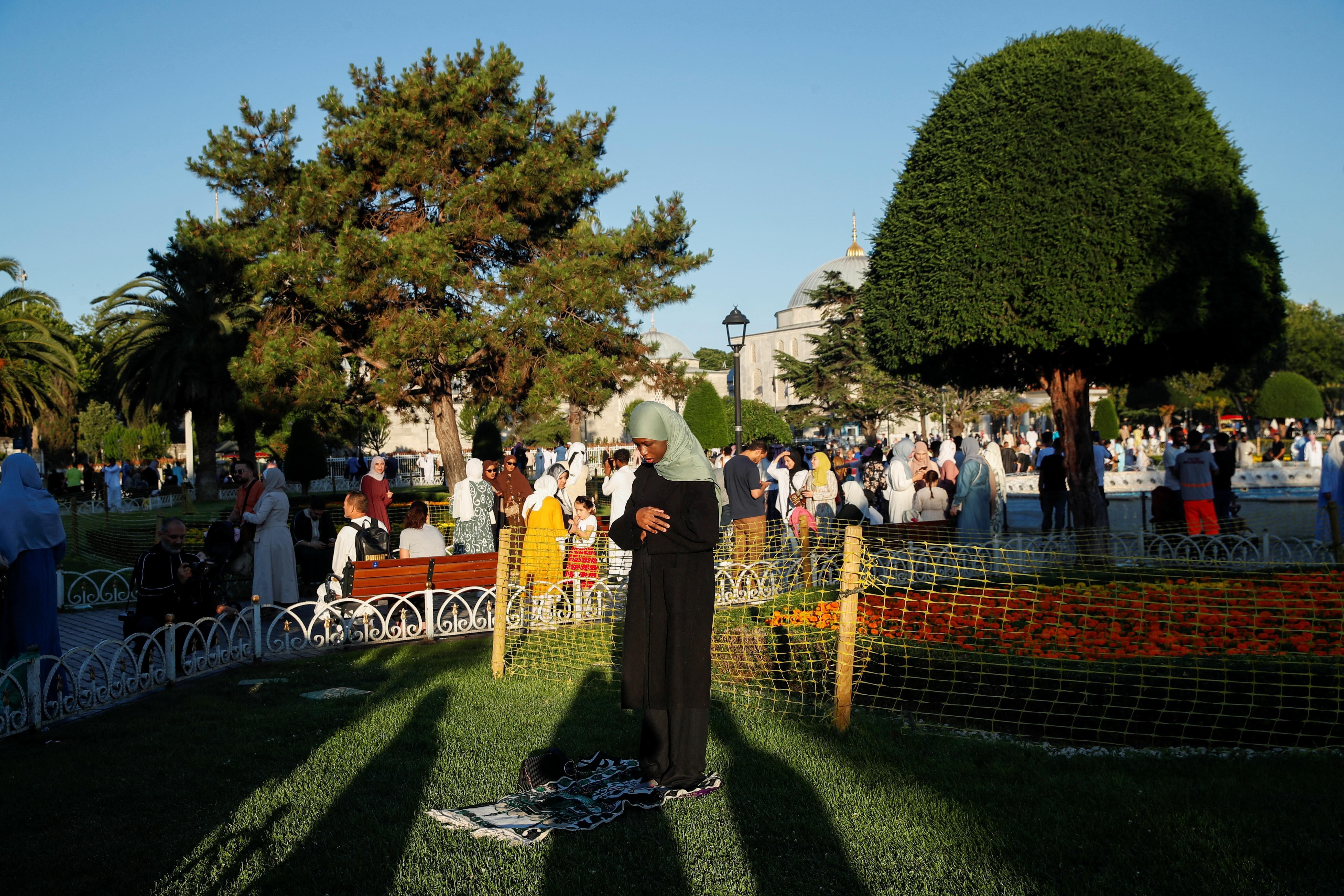 سيدة تؤدي الصلاة في ساحة السلطان أحمد - اسطنبول 
