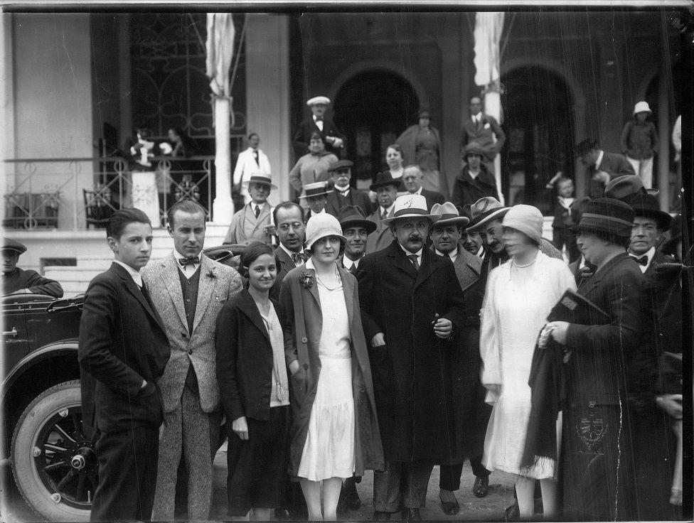 Einstein en el medio, rodeado de varias personas.