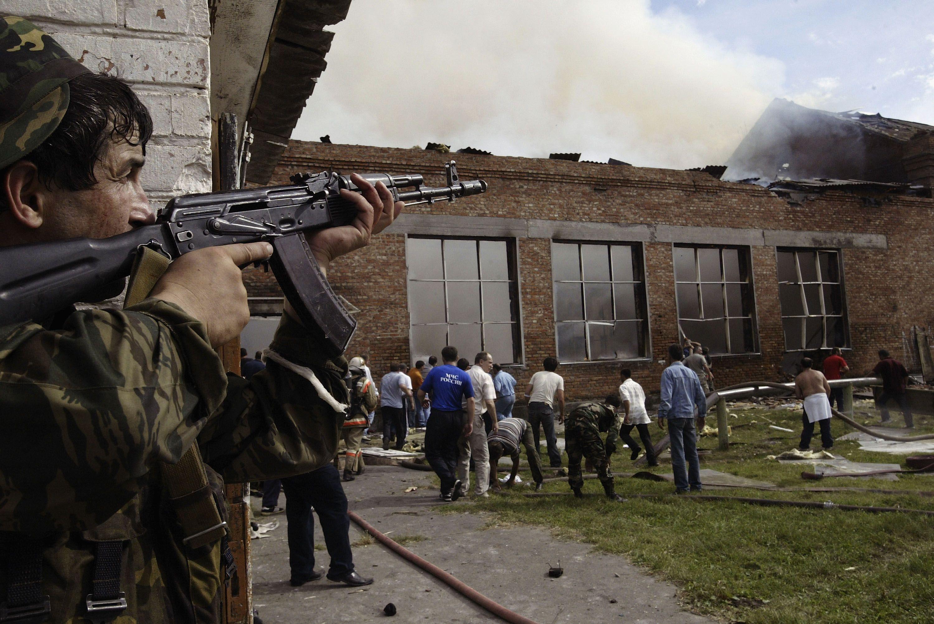 Soldado mirando no telhado da escola durante o cerco.