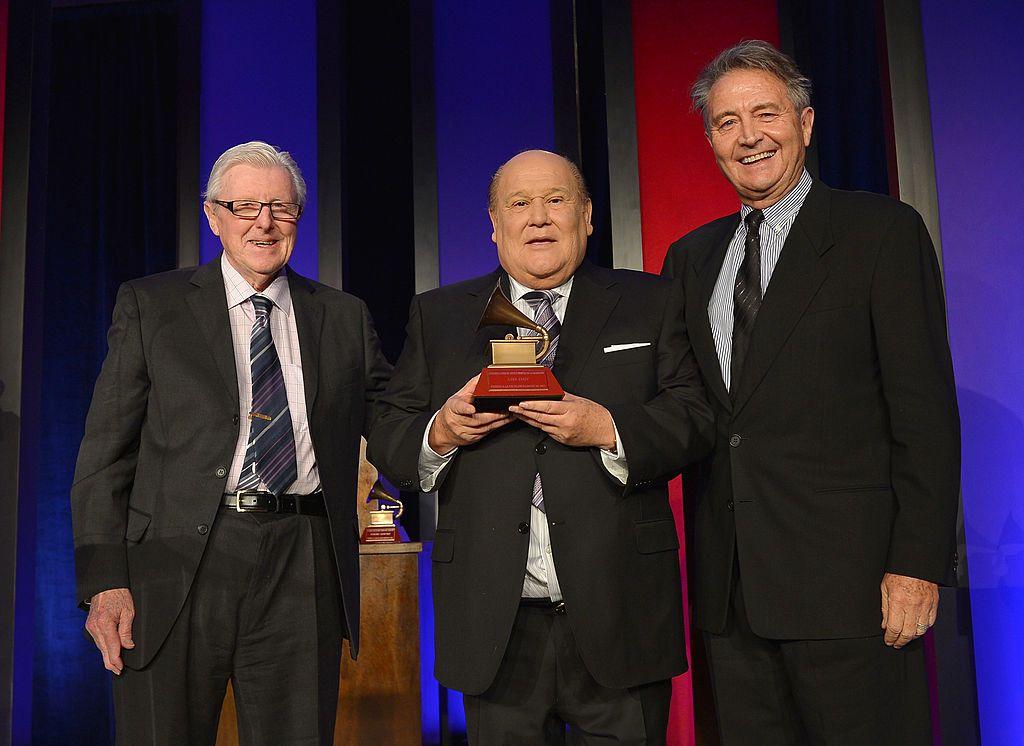 Leo Dan (centro) sostiene el Latin Grammy por Trayectoria Artística, 2012