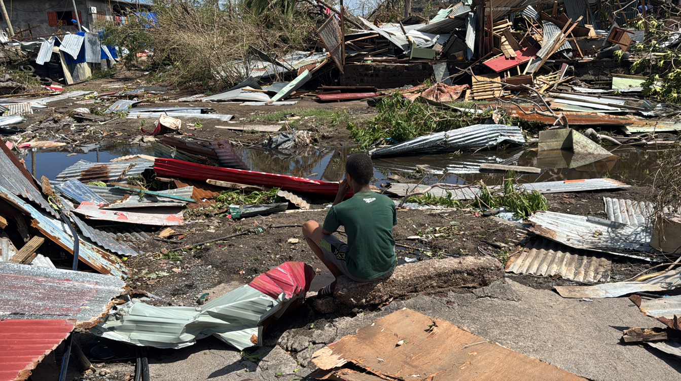 A child looks at the rubble