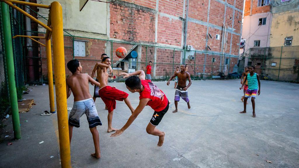 Crianças jogando bola em quadra no Rio de Janeiro