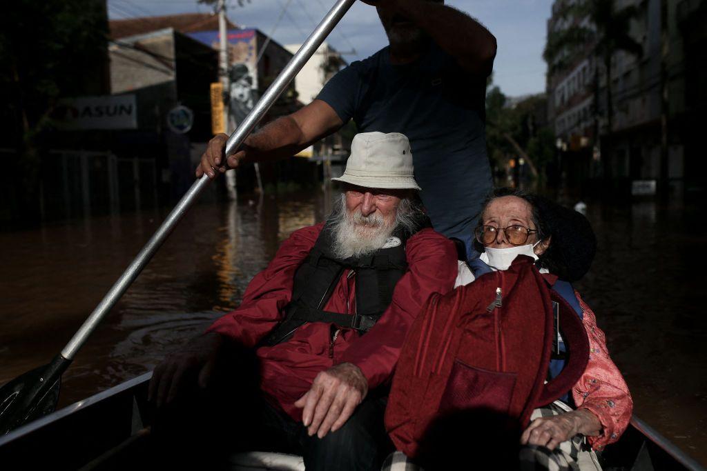 Casal de idosos sendo resgatado em barco