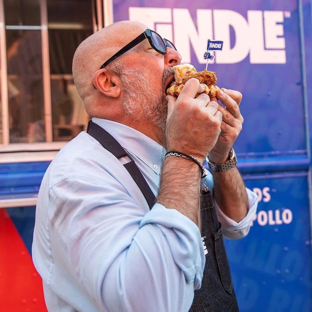 Homem comendo frango com a mão