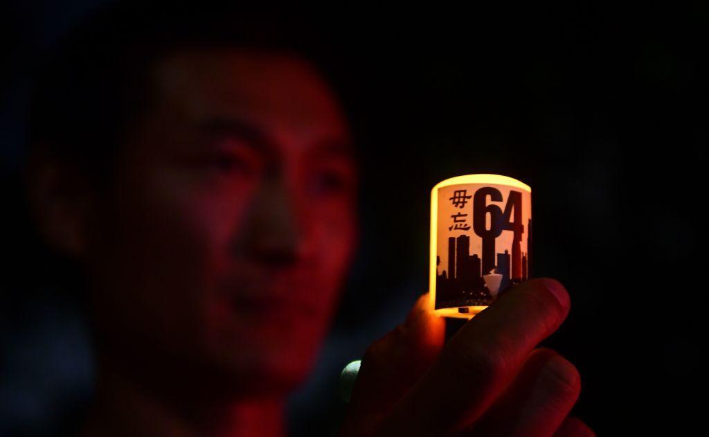 Un hombre sostiene una vela con el número 64 frente al consulado general de China en Los Ángeles, California, en el 30 aniversario de la masacre de Tiananmen