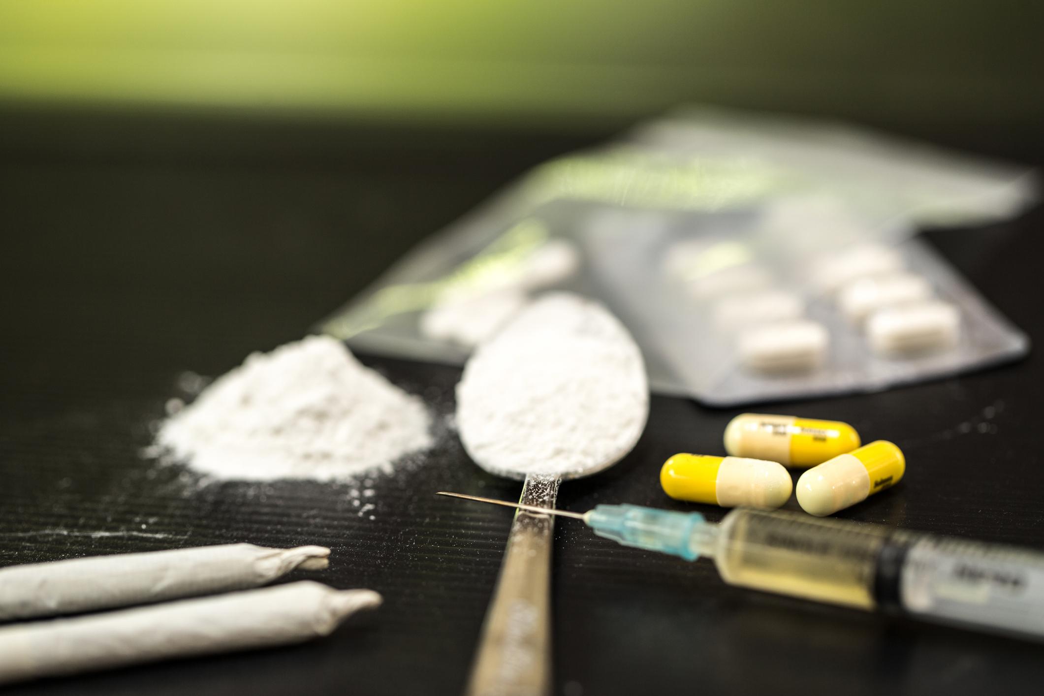 Una cucharillas con cocaína, dos porros de marihuana, una inyectora con heroína junto a pastillas.