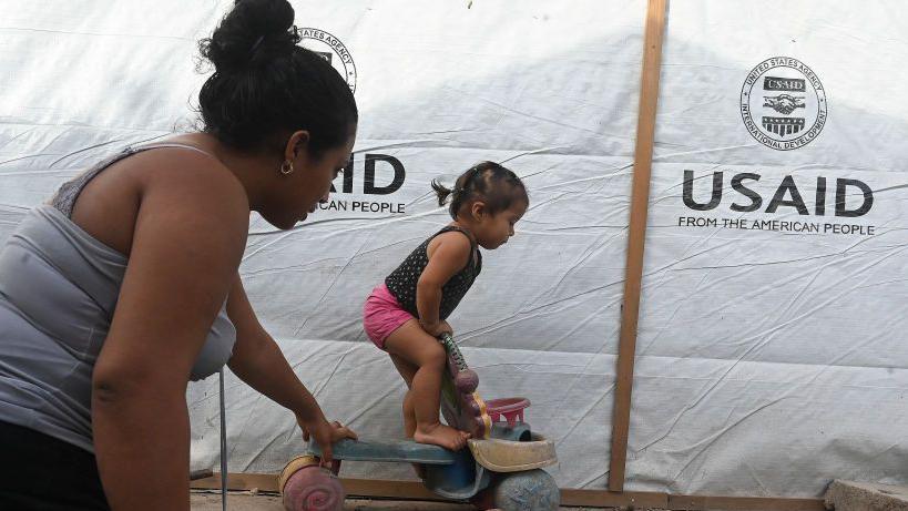 Una mujer juega con su hija en un una choza improvisada que construyó con la ayuda de la Agencia de los Estados Unidos para el Desarrollo Internacional (USAID) en Honduras tras una riada. 