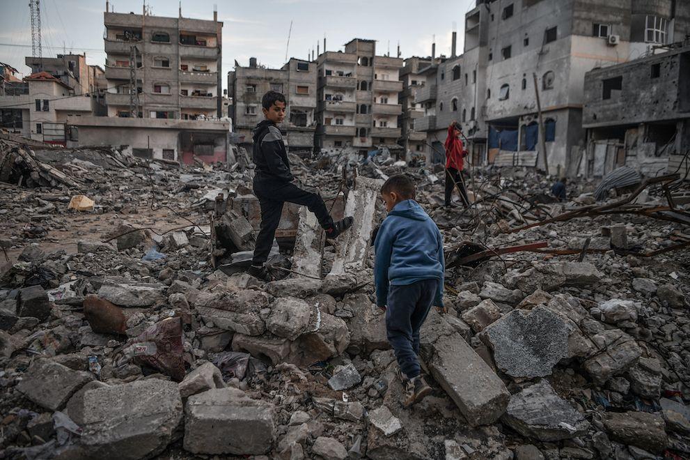 Palestinian boys are seen in the rubble of a building destroyed by an Israeli attack in Rafah, Gaza on 3 January 2024
