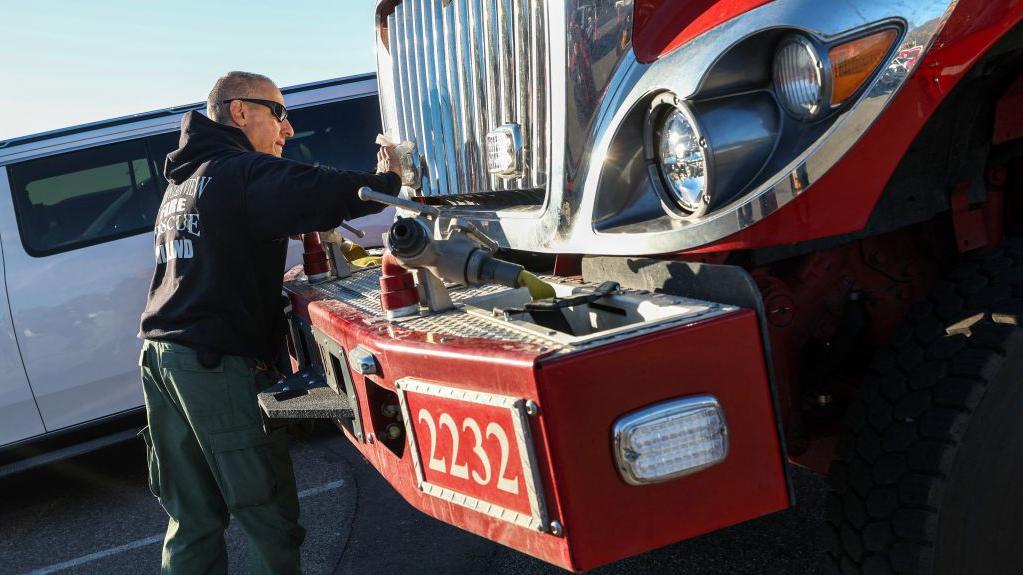 Un miembro del servicio de emergencias de Mountain View junto a un camión de bomberos en Los Ángeles