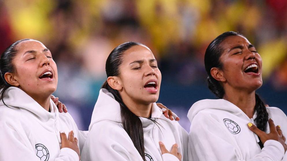 Jugadoras colombianas cantando su himno nacional.