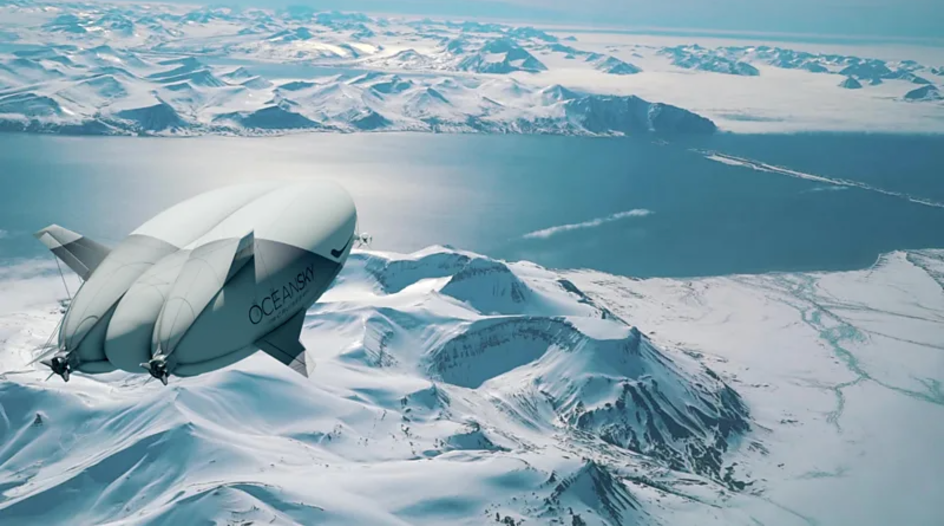 Dirigível branco sobrevoa uma paisagem de montanhas nevadas, com um vasto lago ao fundo, sob céu limpo e tons gelados