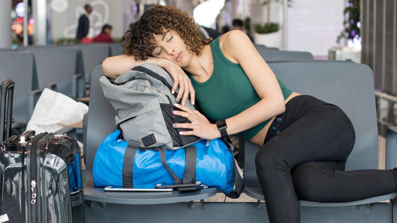 Una mujer duerme en un aeropuerto