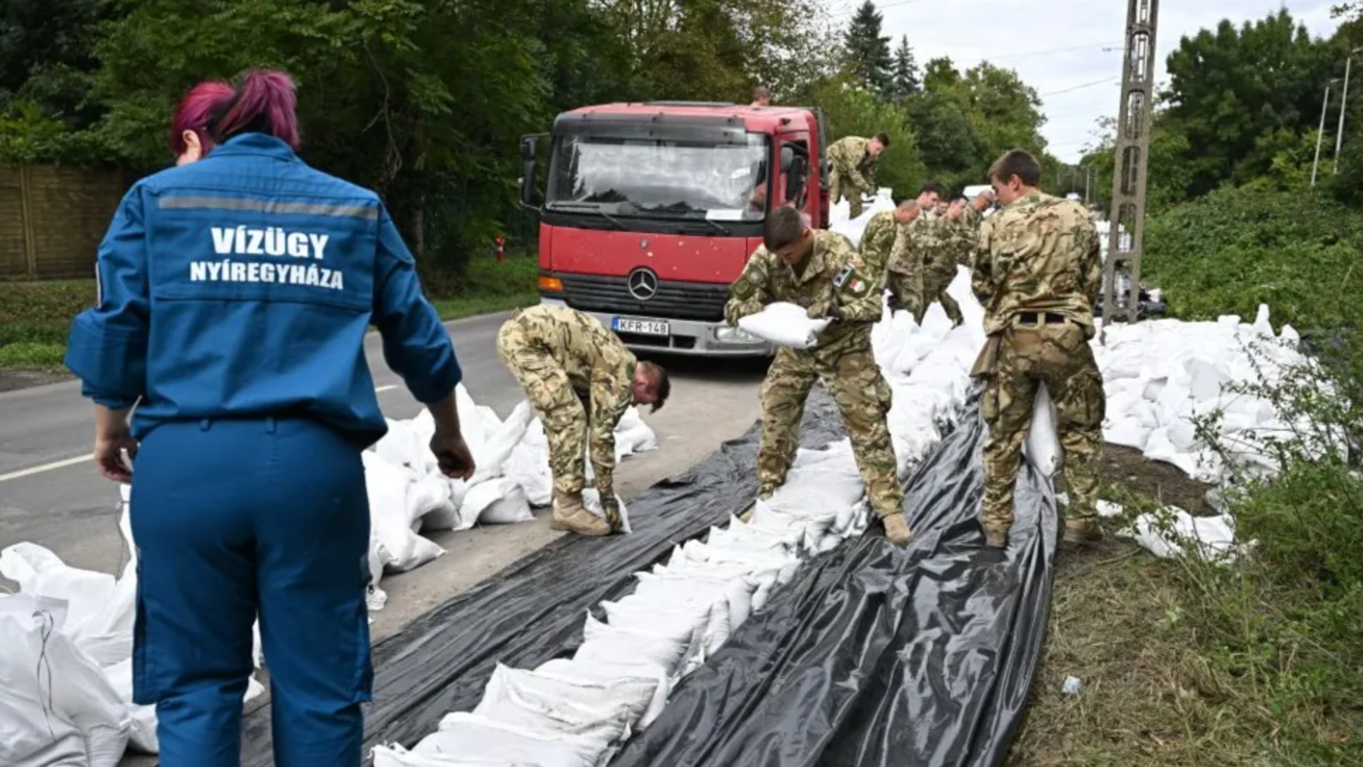 Венгерские солдаты в деревне Леанифалу помогают возводить заграждения от наводнений с помощью мешков с песком
