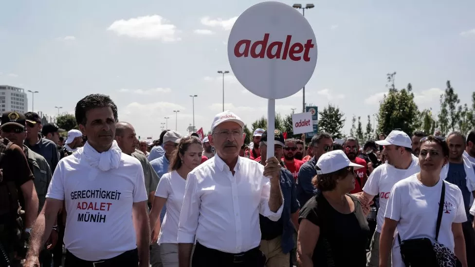 Kemal Kilicdaroglu carregando placa pedindo por justiça durante ato contra erdogan