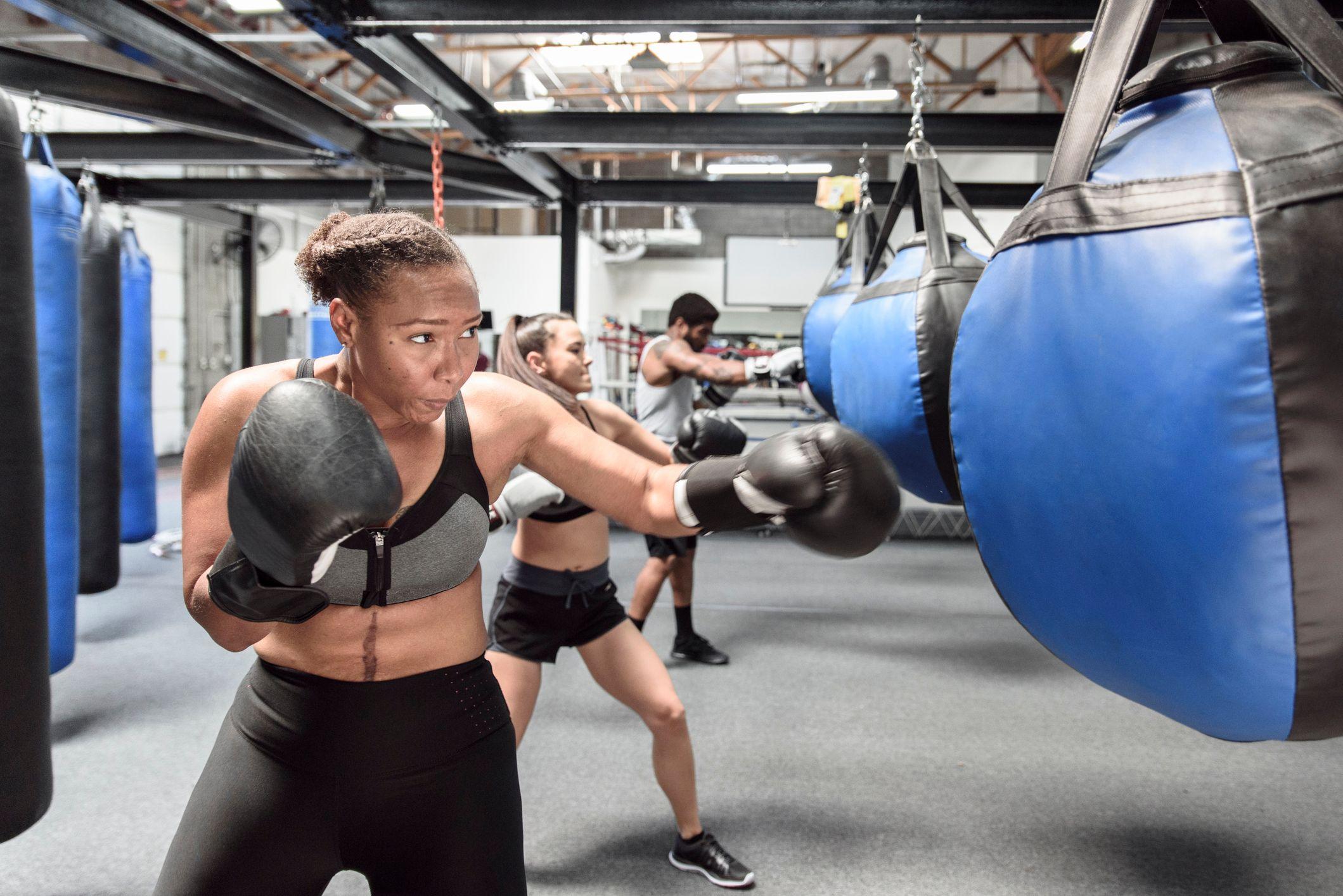 Pessoas treinando boxe com saco de pancadas