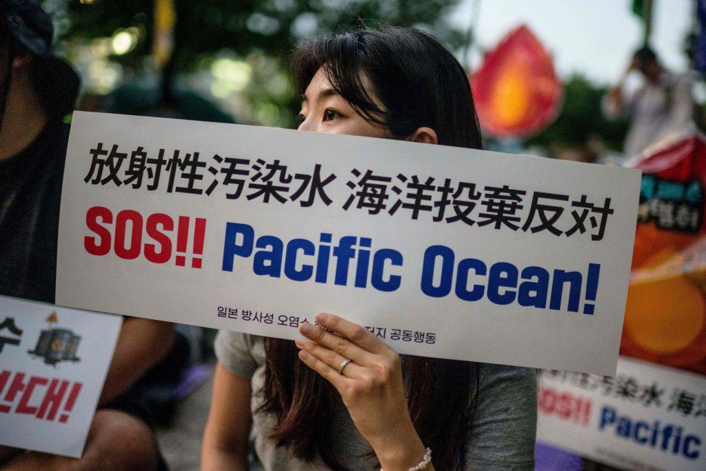 ناشطة تحمل لافتة كتب عليها "النجدة!! المحيط الهادئ!" بينما تحتج هي وآخرون على التصريف المخطط للمياه من محطة فوكوشيما النووية المنكوبة في اليابان إلى المحيط الهادئ، وذلك خارج سيتي هول في سول في 22 أغسطس/ آب 2023