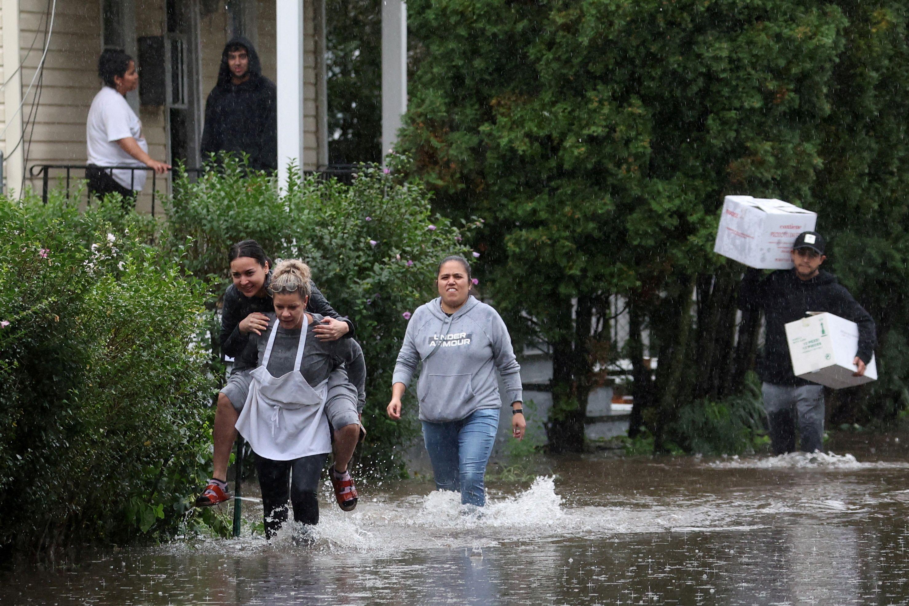 Personas atravesando una calle inundada