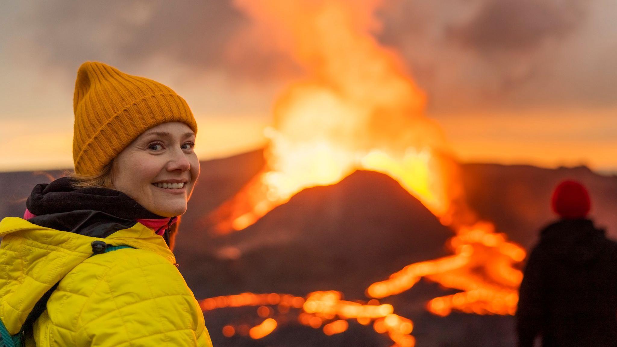 Una mujer delante de un volcán.