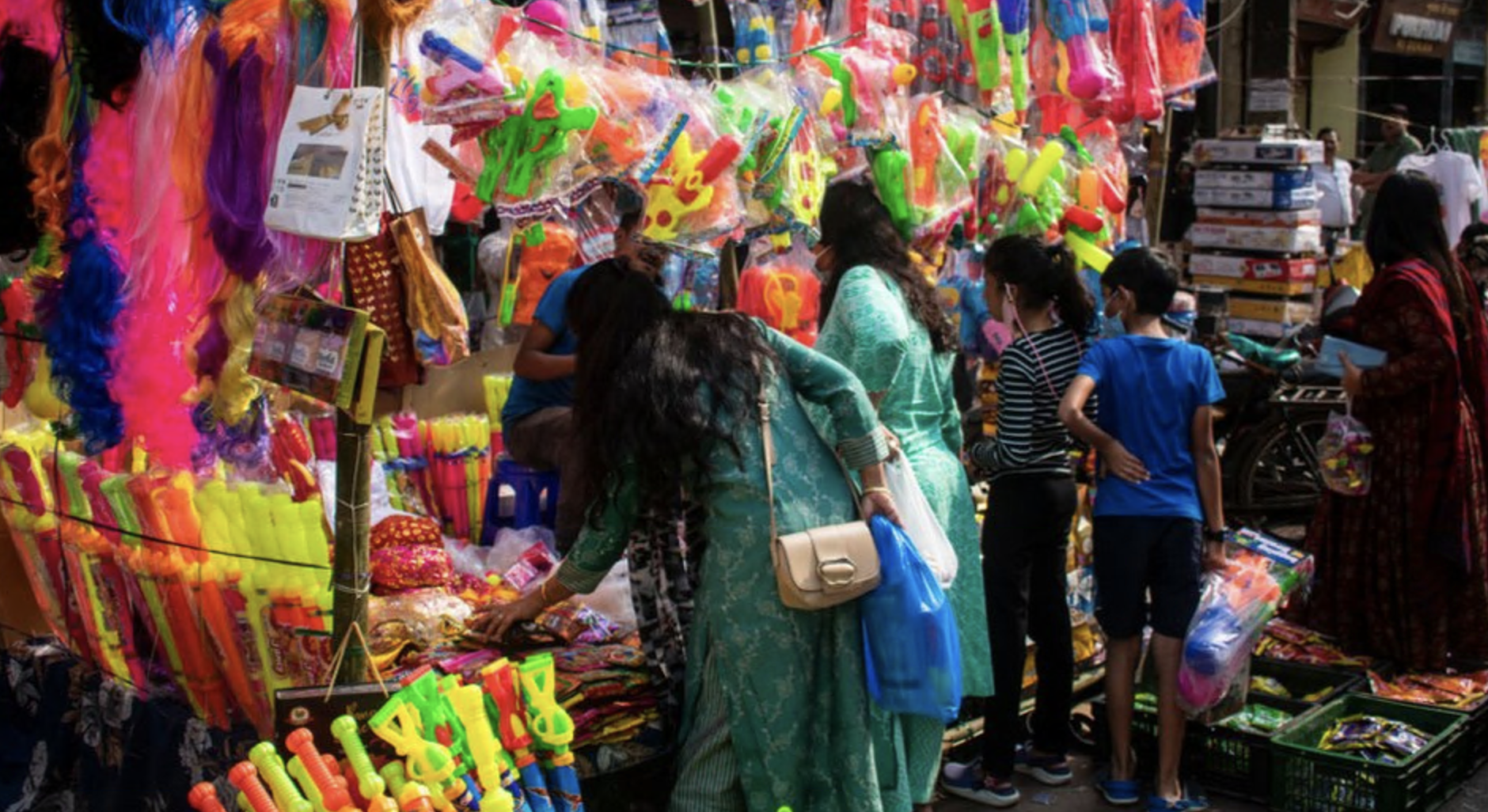 Street vendor selling Pichkari (Water gun) and other Holi celebration items at a market