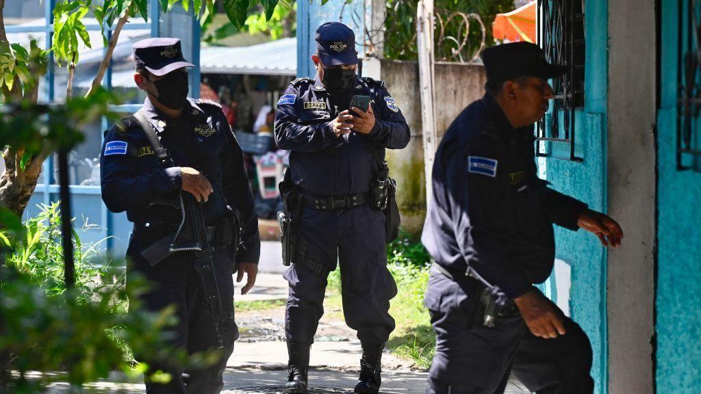 Policías de El Salvador entran a una casa