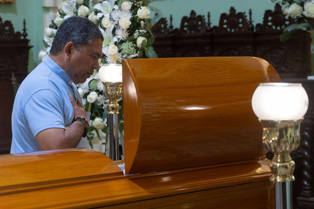 A man approaches Gutiérrez's coffin, in Lima, Peru. 