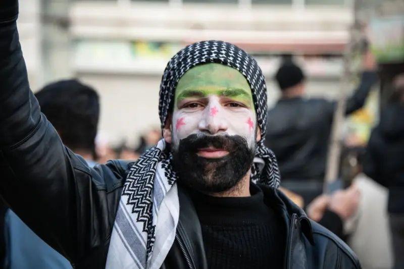 Un refugiado sirio con la cara pintada con la bandera siria celebra en Ankara, Turquía.