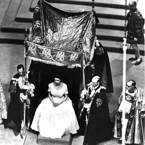 Rainha Elizabeth 2ª sentada em trono sob dossel 