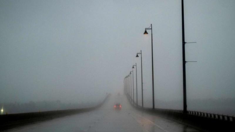 Carro sob forte chuva andando em viaduto