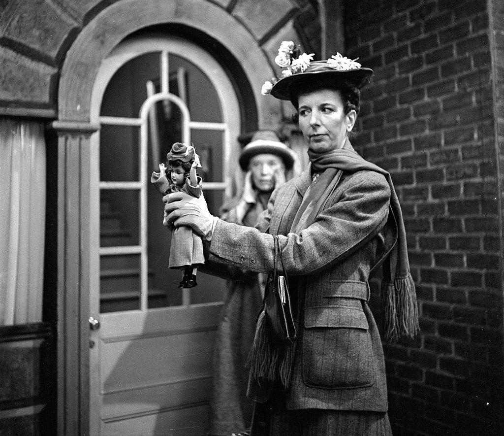 Mary Wickes interpretando a Mary Poppins con una muñeca en la mano