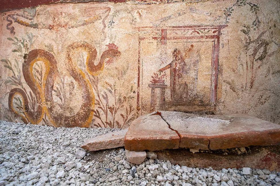 Frescos que muestran una gran serpiente y una figura humana 