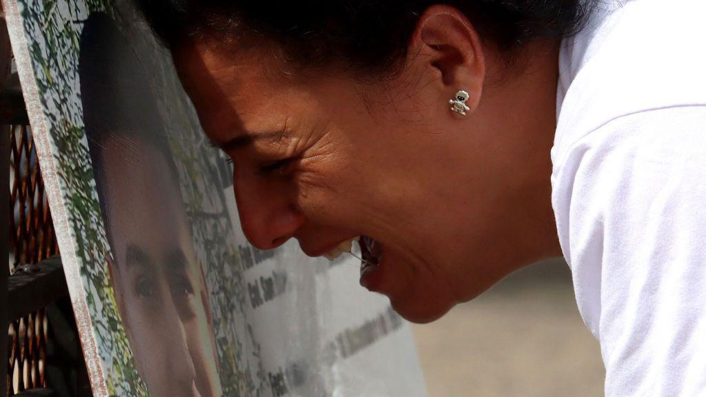 Uma mulher chora diante do retrato de uma pessoa desaparecida no México.