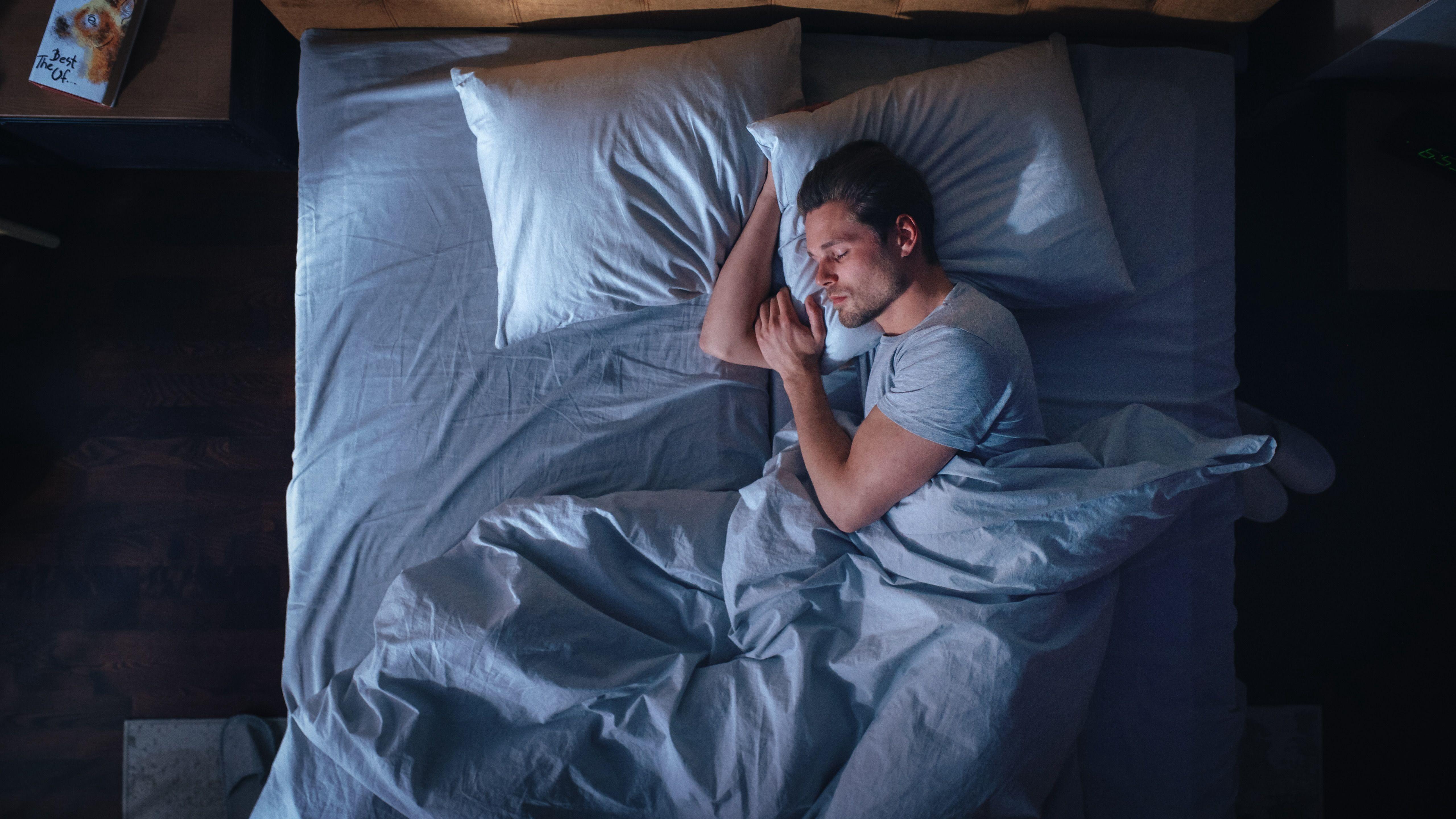 Man sleeping, covered by a weighted blanket 