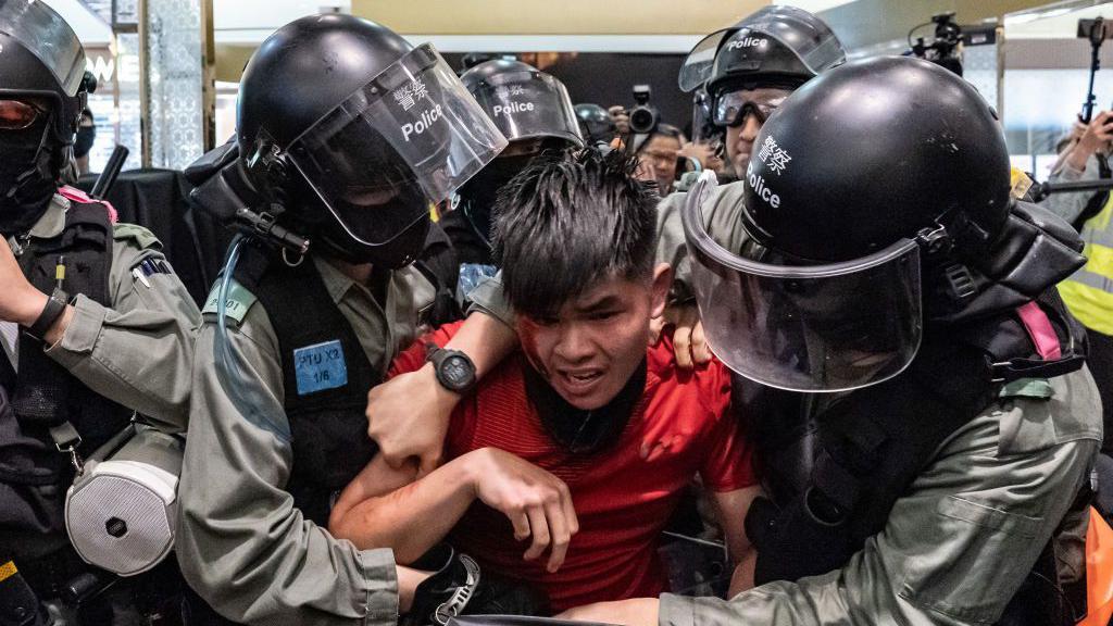 La policía arresta a un joven universitario durante las protestas pro-democracia de 2019