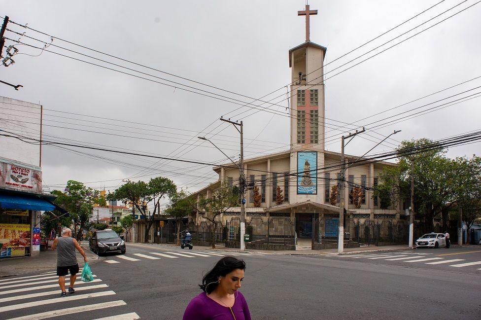 rua da Vila Medeiros, em frente a igreja católica. pessoas andando