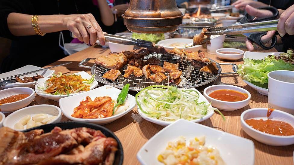 Platillos de banchan en torno a una barbacoa en el centro de una mesa