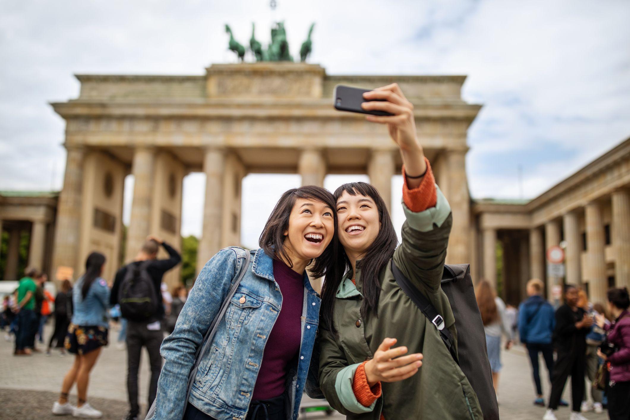 Wisatawan berswafoto di Gerbang Brandenburg, Berlin.