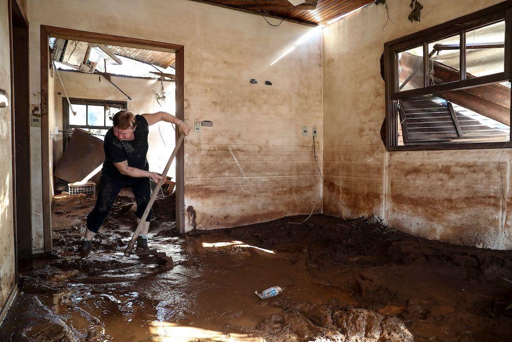 Mulher limpando casa com lama