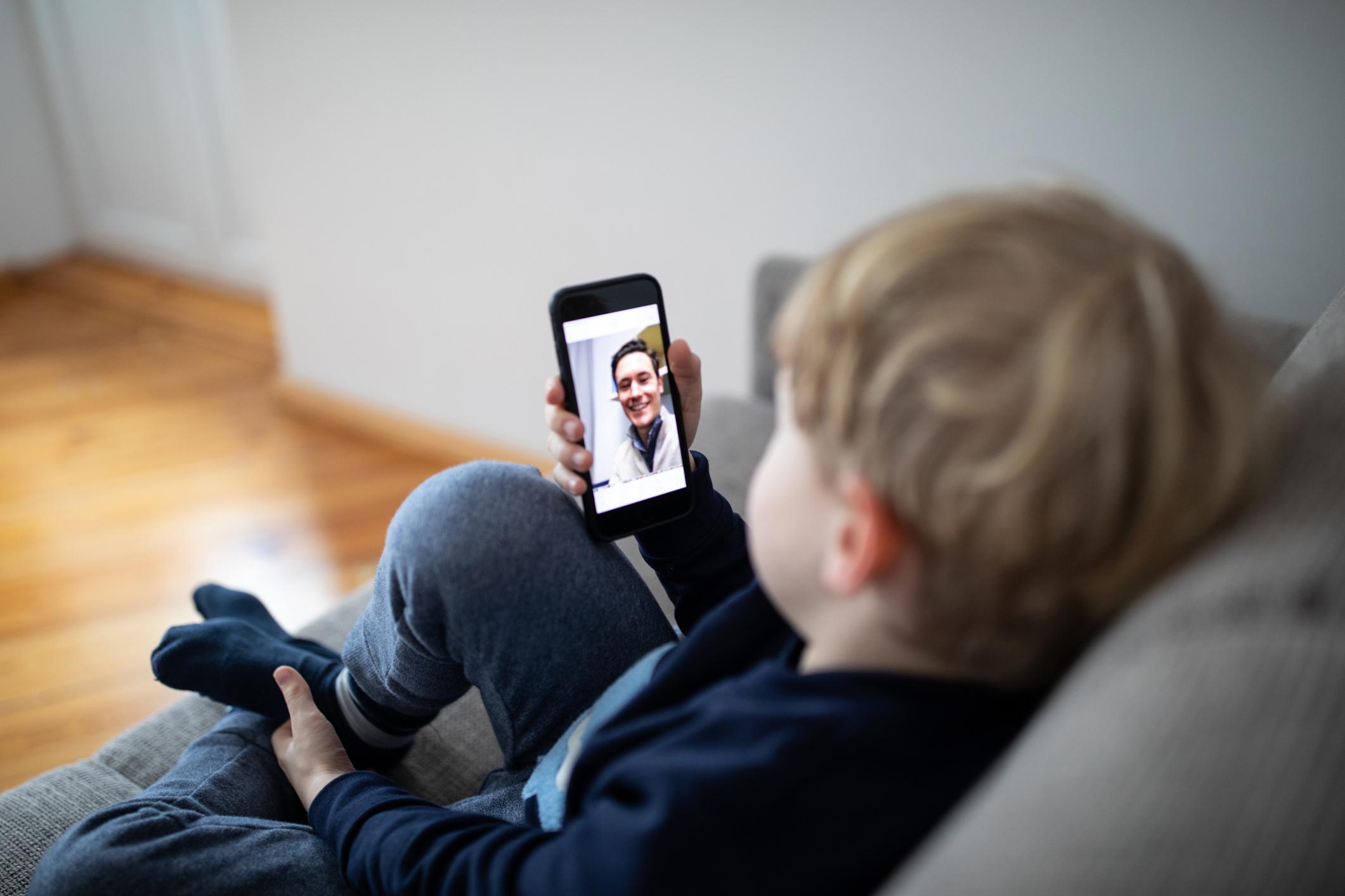 Criança fala com pai por telefone